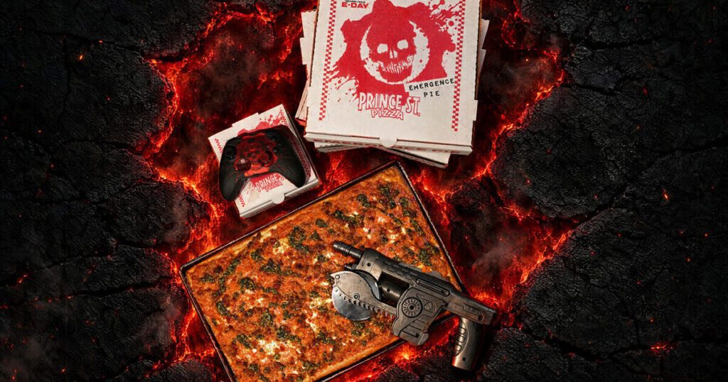 Pizza con condimenti piccanti accanto a un tagliapizza ispirato a un fucile da Gears