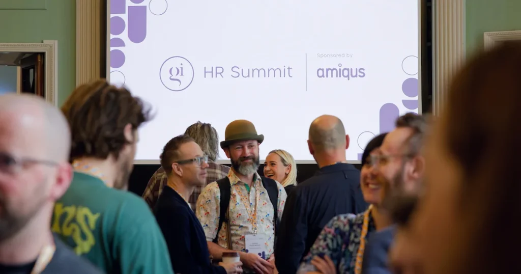 Sala conferenze a Londra con palco pubblico e schermi dedicati a lavoro e tecnologia nel gaming