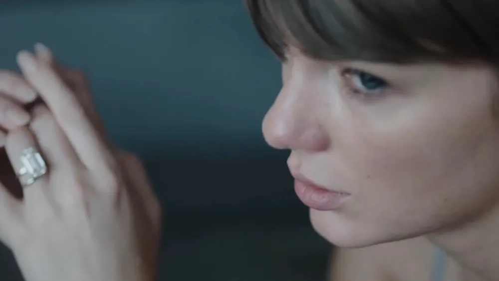 Taylor Swift in una scena dal look cinematografico con luci da premio musicale