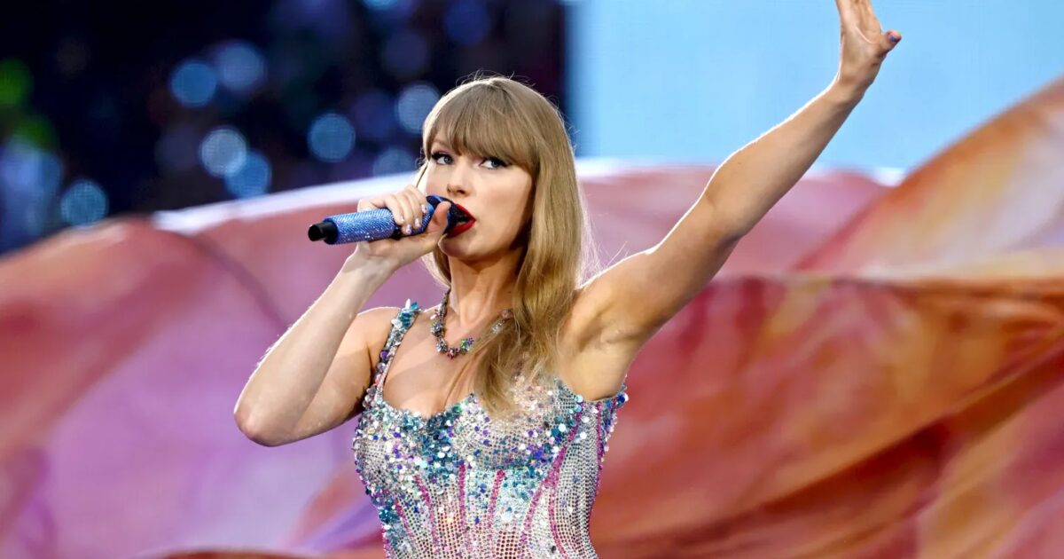 Taylor Swift sul palco con luci live e atmosfera da premio musicale Gamescafe Taylor Swift sul palco con luci live e atmosfera da premio musicale