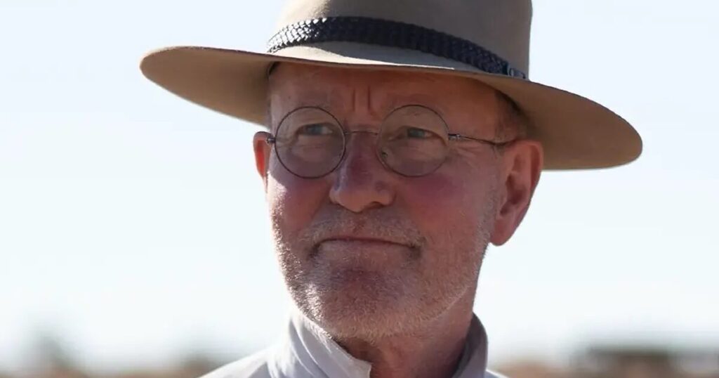 Rolf de Heer in posa durante un festival con sfondo rosso e loghi del Tokyo International Film Festival