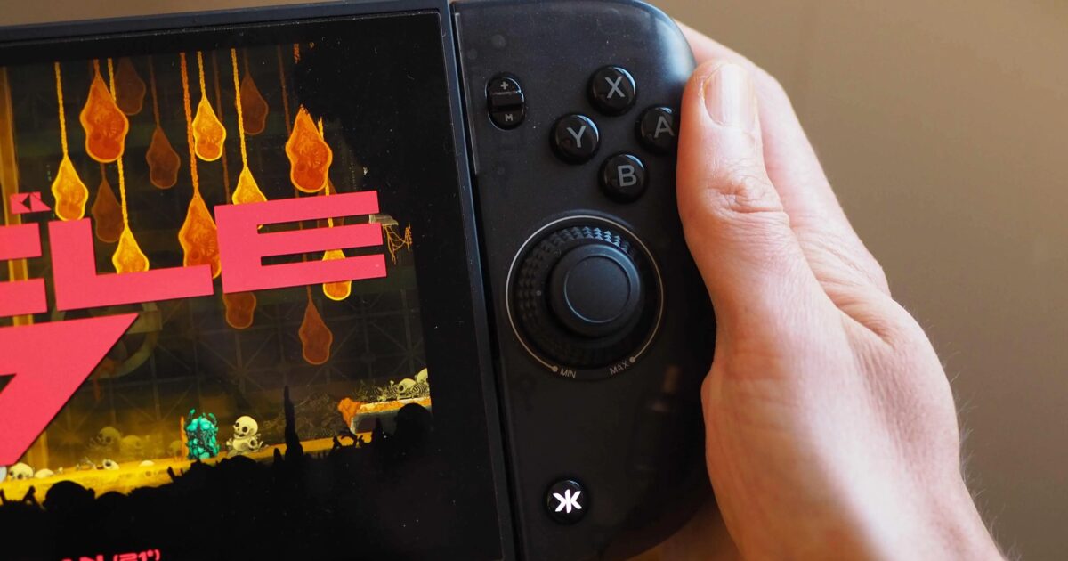 Controller accessorio nero agganciato a una console Switch in modalità portatile Gamescafe Controller accessorio nero agganciato a una console Switch in modalità portatile