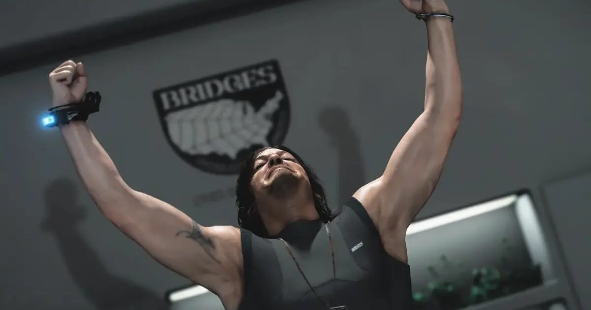 Death Stranding Sam Porter Bridges Gamescafe Sam Porter Bridges con le braccia alzate in una stanza con il simbolo BRIDGES